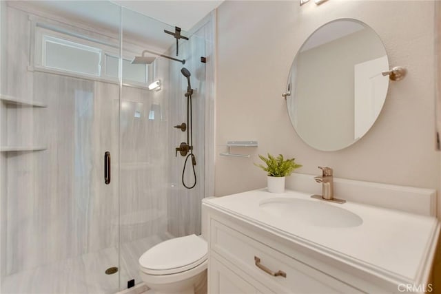 bathroom featuring vanity, a shower stall, and toilet