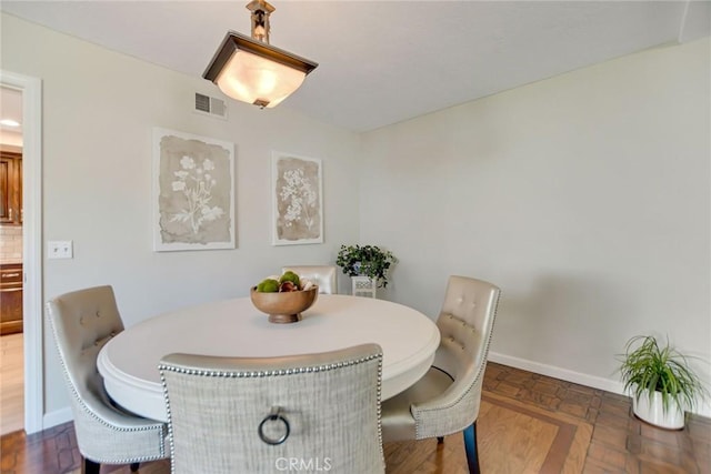dining space featuring baseboards and visible vents