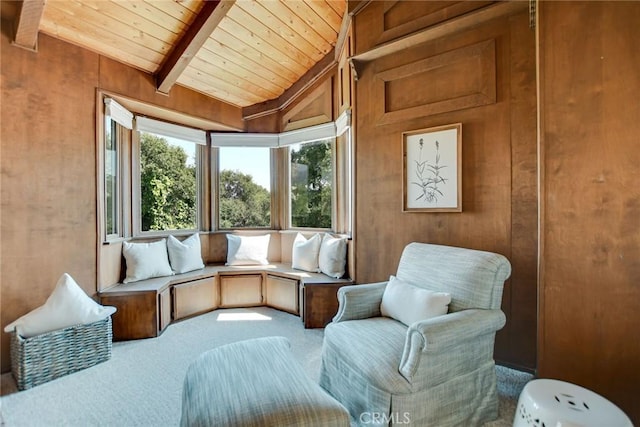 living area featuring carpet flooring, vaulted ceiling with beams, wood walls, and wood ceiling