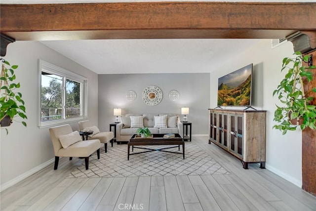 living room with light wood-type flooring, baseboards, and visible vents