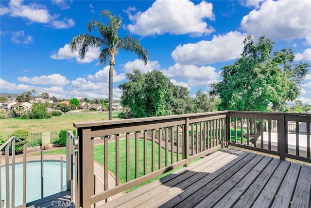 wooden deck with a fenced in pool and a lawn