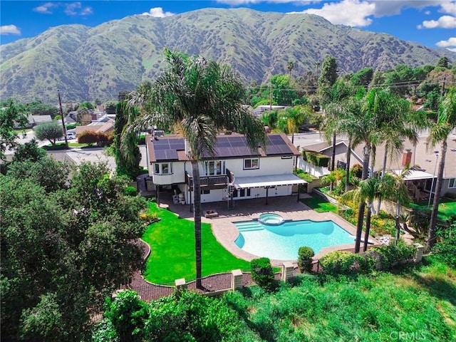 view of swimming pool with a lawn, a patio, a pool with connected hot tub, and a fenced backyard