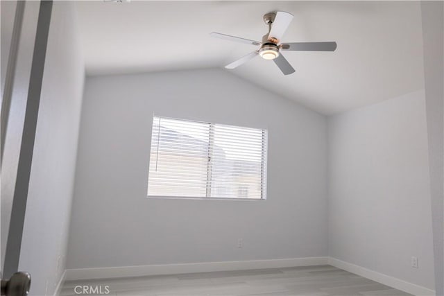 unfurnished room featuring light wood-type flooring, baseboards, ceiling fan, and lofted ceiling