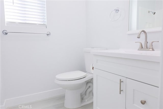 bathroom with vanity, baseboards, and toilet