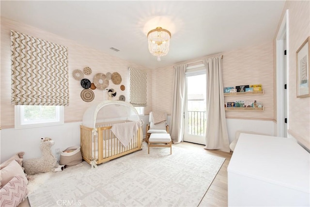 13 Goldenrod, Lake Forest, CA 92630 - bedroom with multiple windows, a chandelier, wallpapered walls, wood finished floors, and access to outside