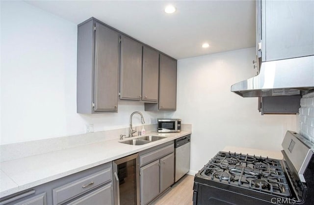 8641 Glenoaks Blvd Unit 107, Sun Valley, CA 91352 - kitchen featuring stainless steel appliances, gray cabinetry, beverage cooler, a sink, and ventilation hood