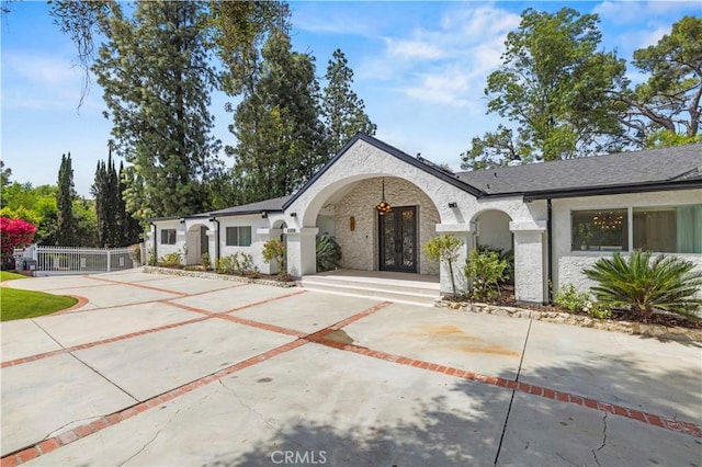4250 Louise Ave, Encino, CA 91316 - view of front of home with french doors, fence, concrete driveway, stone siding, and stucco siding