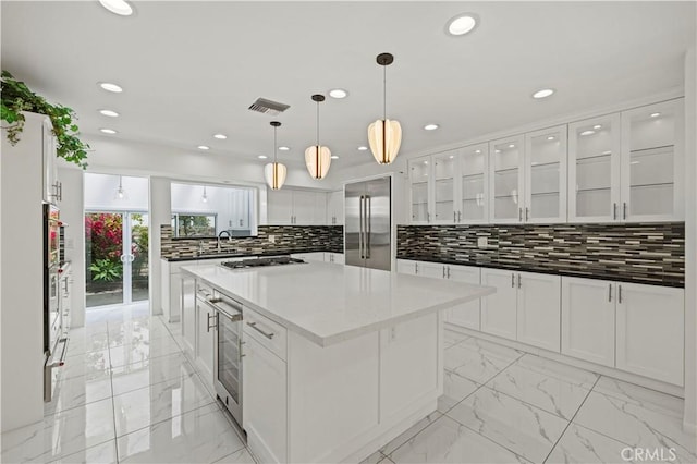 4250 Louise Ave, Encino, CA 91316 - kitchen with visible vents, marble finish floor, a kitchen island, beverage cooler, and stainless steel appliances