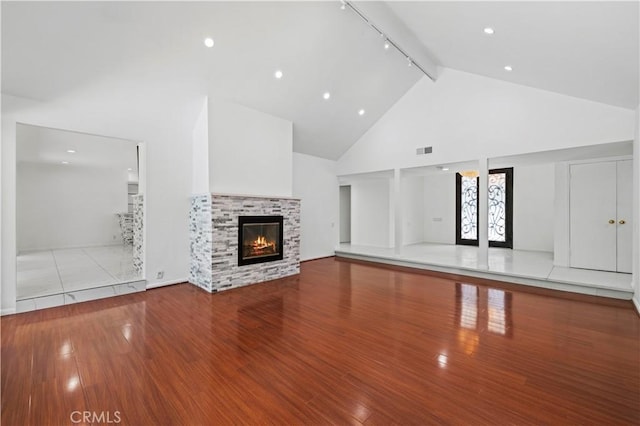 4250 Louise Ave, Encino, CA 91316 - unfurnished living room featuring visible vents, a glass covered fireplace, wood finished floors, high vaulted ceiling, and rail lighting
