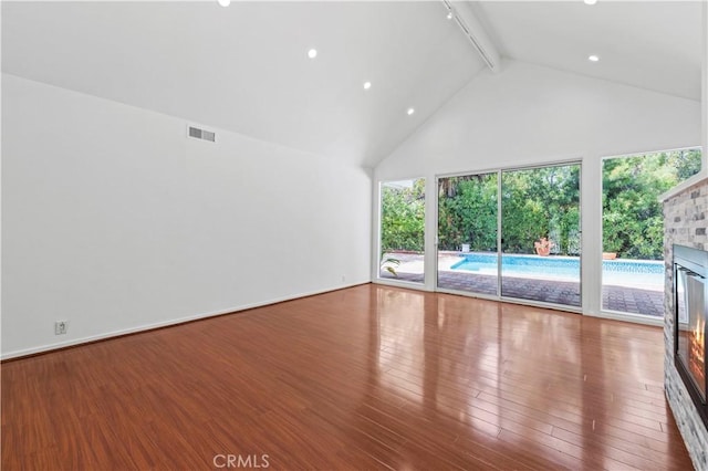 4250 Louise Ave, Encino, CA 91316 - unfurnished living room with visible vents, a glass covered fireplace, beam ceiling, wood finished floors, and high vaulted ceiling