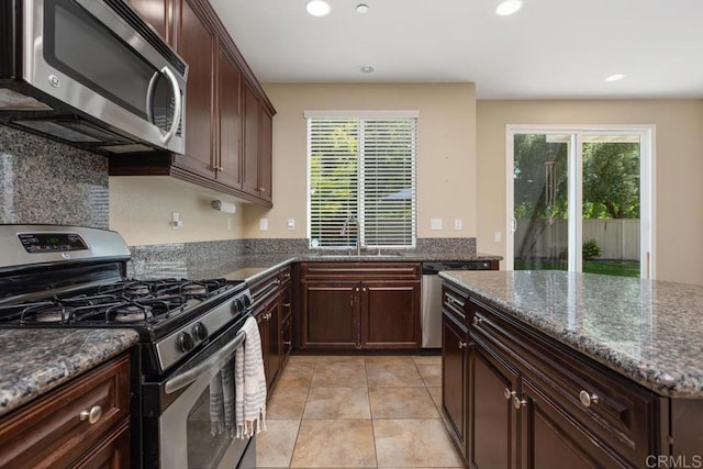 750 Arbor Glen Ln, Vista, CA 92081 - kitchen featuring appliances with stainless steel finishes, a sink, dark stone countertops, recessed lighting, and light tile patterned flooring