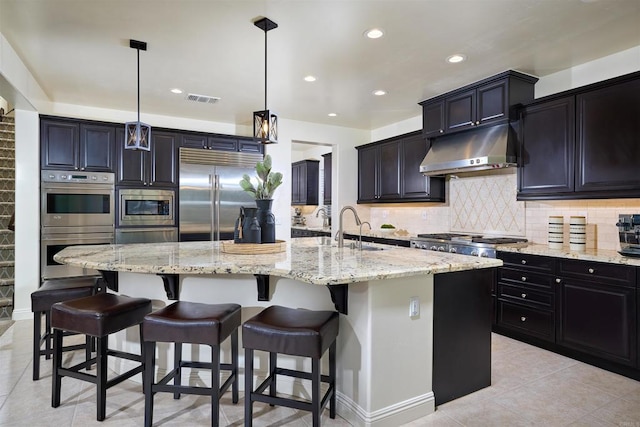 6981 Corte Langosta, Carlsbad, CA 92009 - kitchen featuring built in appliances, under cabinet range hood, light tile patterned flooring, a sink, and light stone counters