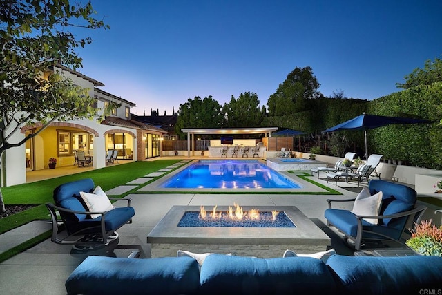 6981 Corte Langosta, Carlsbad, CA 92009 - pool at dusk with a patio, an in-ground hot tub, a fenced backyard, and an outdoor living space with a fire pit