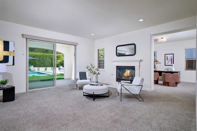 6981 Corte Langosta, Carlsbad, CA 92009 - living area with carpet, a glass covered fireplace, healthy amount of natural light, recessed lighting, and baseboards