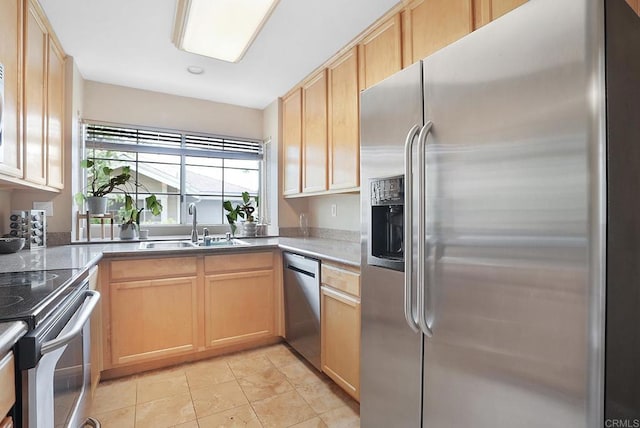 kitchen featuring light brown cabinetry, appliances with stainless steel finishes, light tile patterned flooring, and a sink