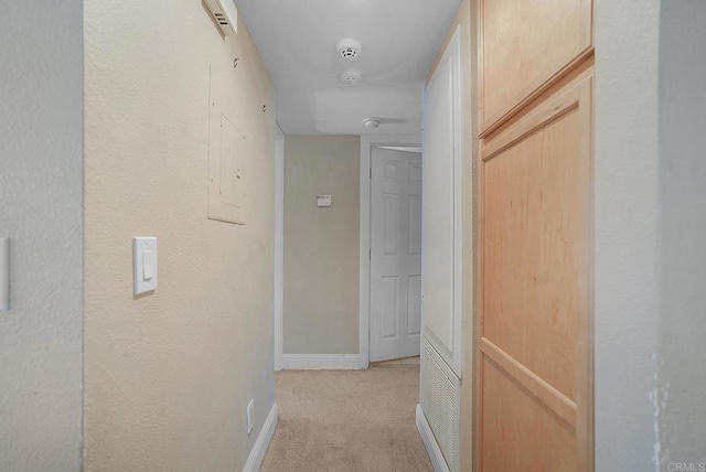 hallway with light colored carpet and baseboards