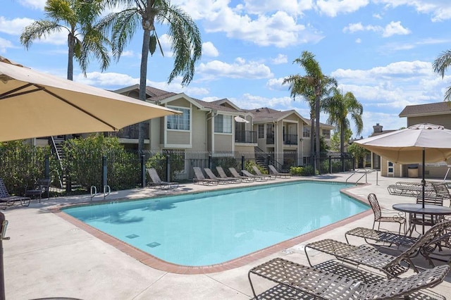 pool with a patio area and fence