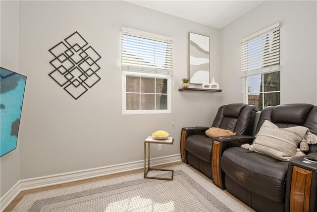 sitting room featuring baseboards, a wealth of natural light, and light wood finished floors