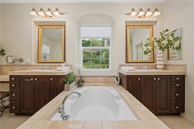 full bath featuring two vanities, a sink, and a bath