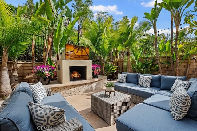 view of patio / terrace featuring a fenced backyard and an outdoor living space with a fireplace