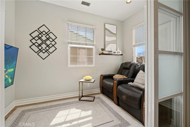 sitting room with visible vents, baseboards, and a healthy amount of sunlight