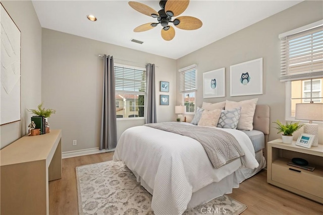 bedroom with visible vents, light wood-style flooring, baseboards, and multiple windows