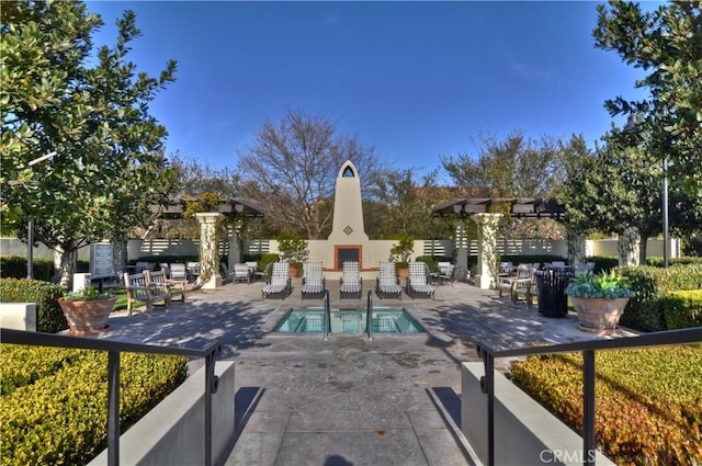 view of swimming pool featuring a patio and an outdoor fireplace