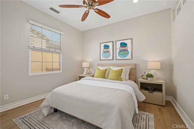 bedroom with light wood-style floors, baseboards, a ceiling fan, and visible vents
