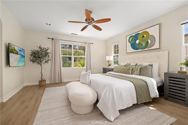 bedroom with baseboards, a ceiling fan, and wood finished floors