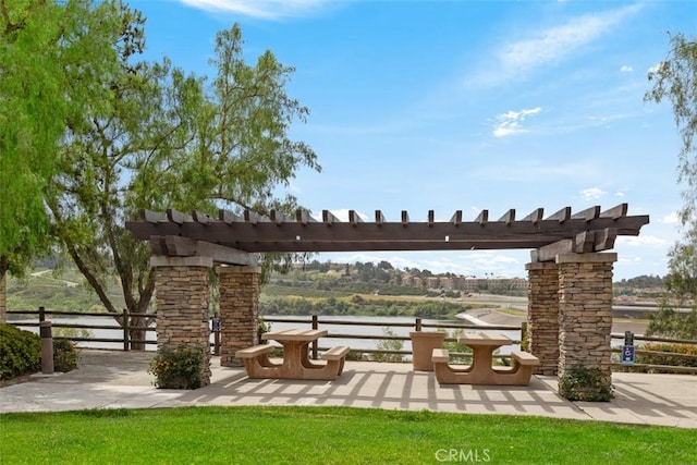 view of community with fence, a patio, and a water view