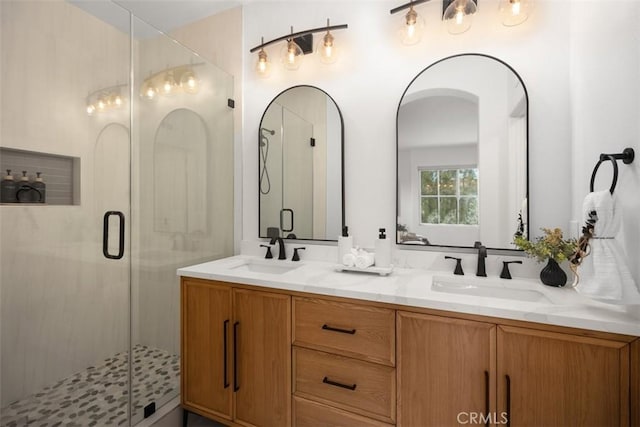 bathroom featuring a stall shower and double vanity