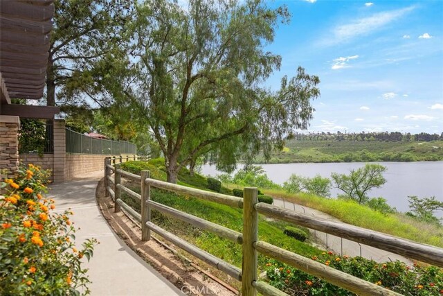 view of yard with a water view and fence