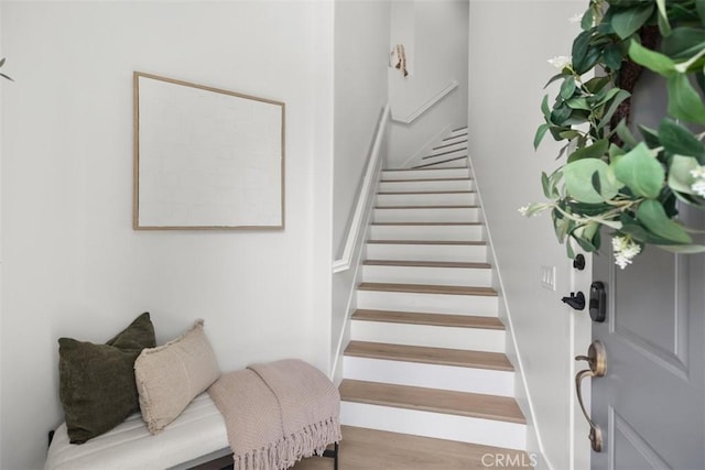 stairs featuring wood finished floors