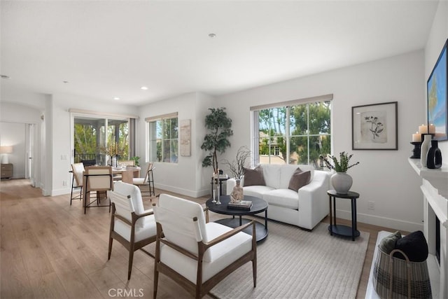 living area featuring light wood finished floors, baseboards, and recessed lighting