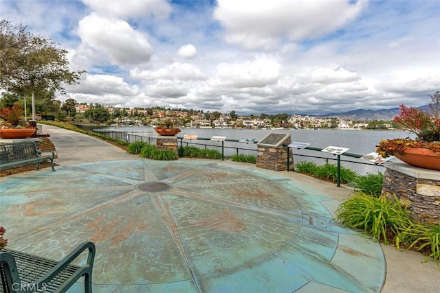 view of patio / terrace with fence and a water and mountain view