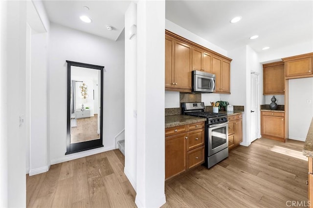6410 Eucalyptus Ave, Chino, CA 91710 - kitchen with brown cabinetry, light wood-type flooring, recessed lighting, dark stone countertops, and stainless steel appliances