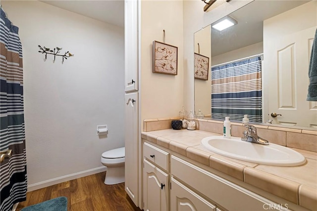 full bathroom with vanity, baseboards, wood finished floors, and toilet