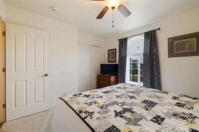 bedroom featuring a ceiling fan, light carpet, and a closet