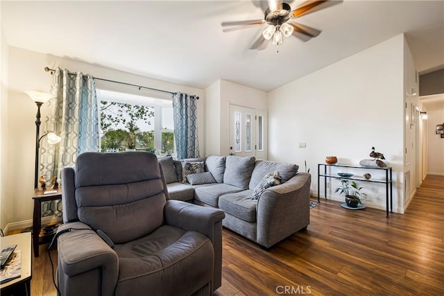 living area featuring dark wood-type flooring, a ceiling fan, baseboards, and lofted ceiling