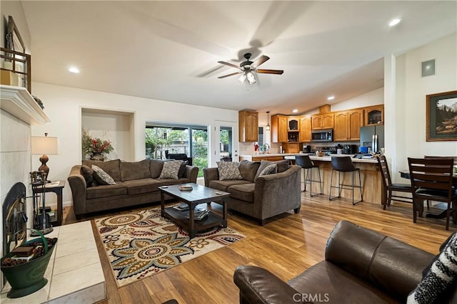 living room featuring recessed lighting, light wood-style flooring, ceiling fan, and lofted ceiling