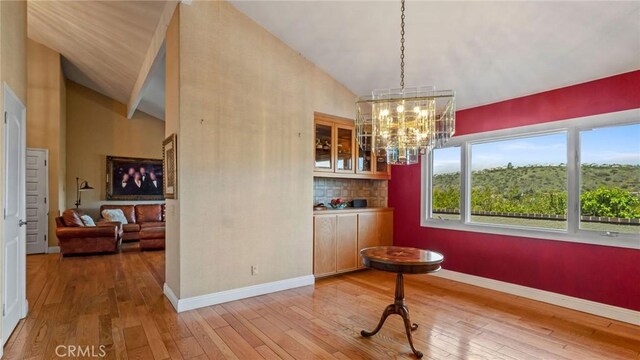 12782 Periwinkle Dr, North Tustin, CA 92705 - dining room with high vaulted ceiling, wood-type flooring, a chandelier, and baseboards