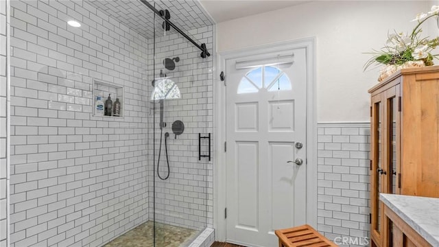 12782 Periwinkle Dr, North Tustin, CA 92705 - full bathroom with a shower stall, tile walls, a wainscoted wall, and vanity