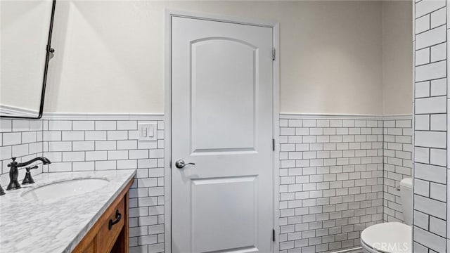12782 Periwinkle Dr, North Tustin, CA 92705 - bathroom featuring vanity, tile walls, toilet, and wainscoting