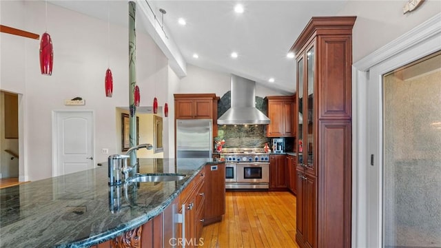 12782 Periwinkle Dr, North Tustin, CA 92705 - kitchen with wall chimney exhaust hood, appliances with stainless steel finishes, a sink, light wood finished floors, and decorative backsplash