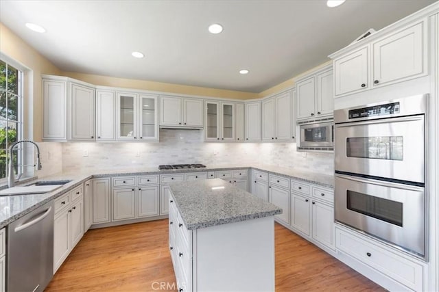 27020 Island Rd, Valencia, CA 91355 - kitchen featuring stainless steel appliances, a center island, tasteful backsplash, white cabinets, and recessed lighting