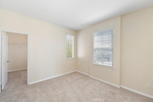27020 Island Rd, Valencia, CA 91355 - unfurnished bedroom with light carpet, multiple windows, and a spacious closet
