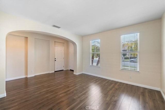 27020 Island Rd, Valencia, CA 91355 - empty room with arched walkways and dark wood-style floors