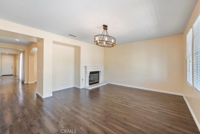 27020 Island Rd, Valencia, CA 91355 - unfurnished living room with dark wood-type flooring, arched walkways, healthy amount of natural light, and a chandelier