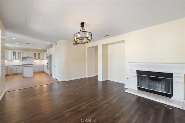 27020 Island Rd, Valencia, CA 91355 - unfurnished living room with recessed lighting, a chandelier, dark wood-style floors, and a glass covered fireplace