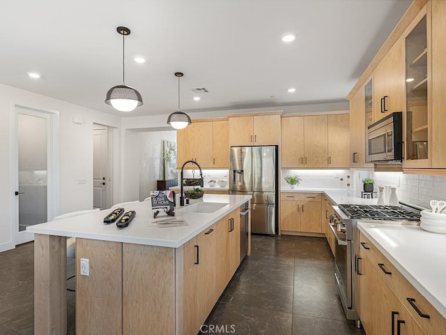 kitchen with decorative backsplash, light brown cabinetry, light countertops, a sink, and appliances with stainless steel finishes